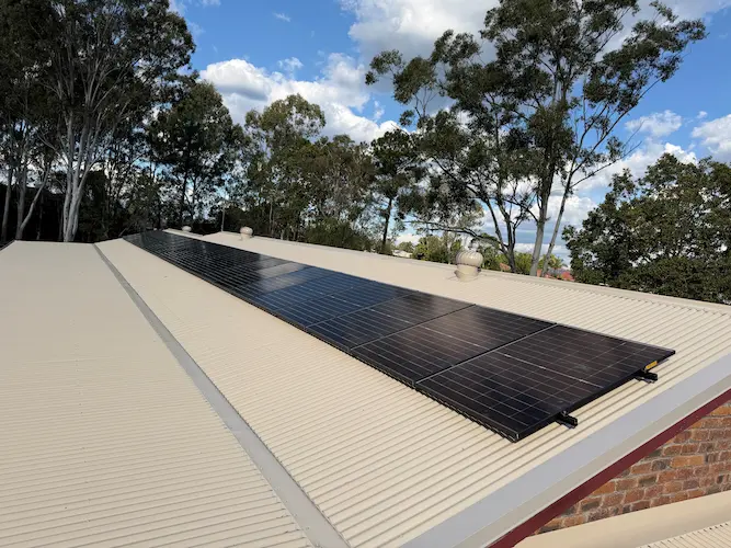 Solar panels installed on a residential tile roof, surrounded by trees