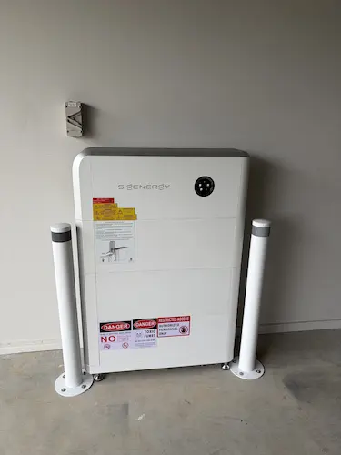 SigEnergy home battery system installed in a garage with protective bollards, Ripley QLD