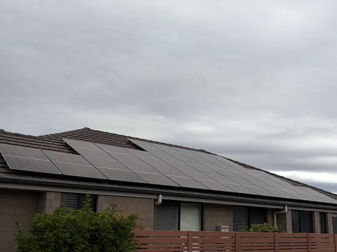Black solar panel array installed across a tiled roof on a home in Ripley, QLD